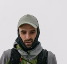 Man in hiking gear with cap and hood
